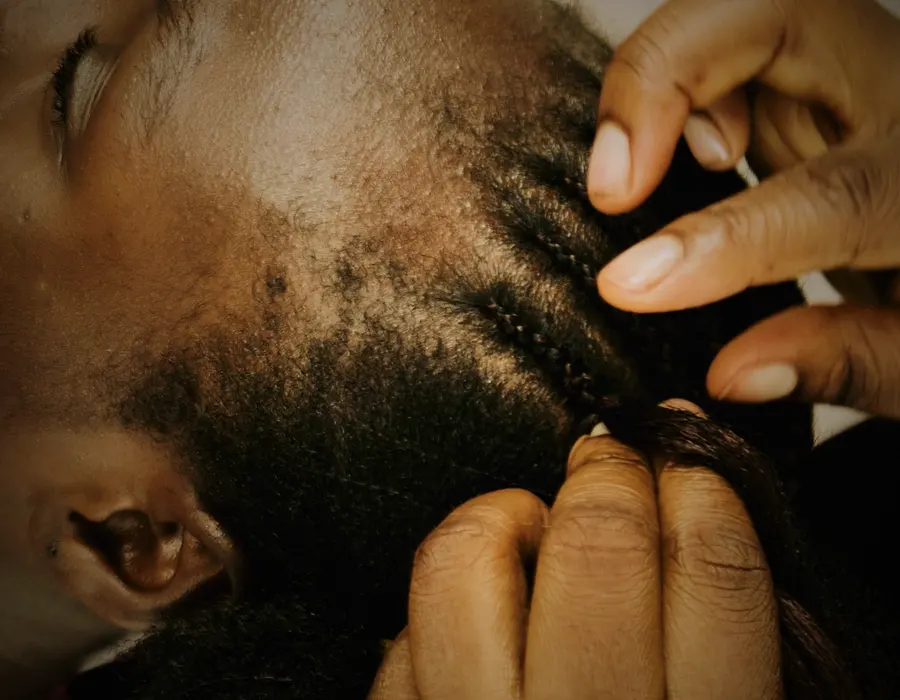 Mains qui travaillent une coiffure au ras du cuir chevelu